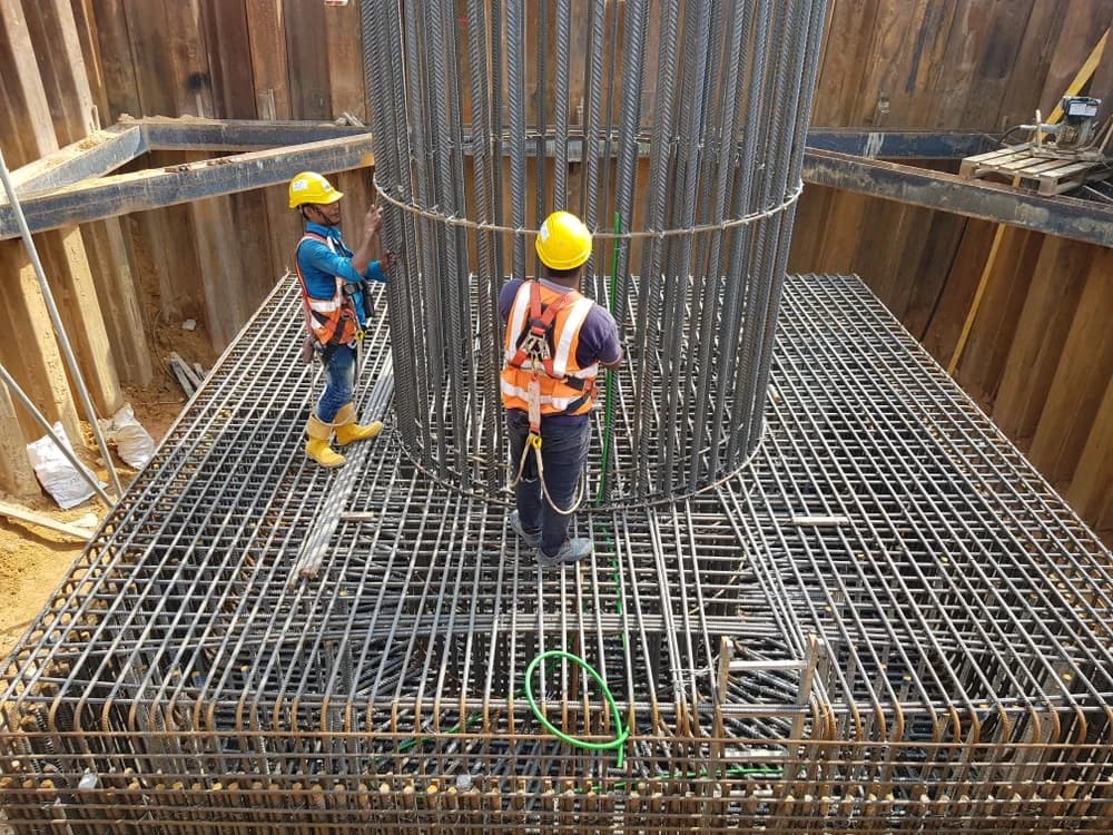 Steel fixers preparing reinforced foundations on a construction site