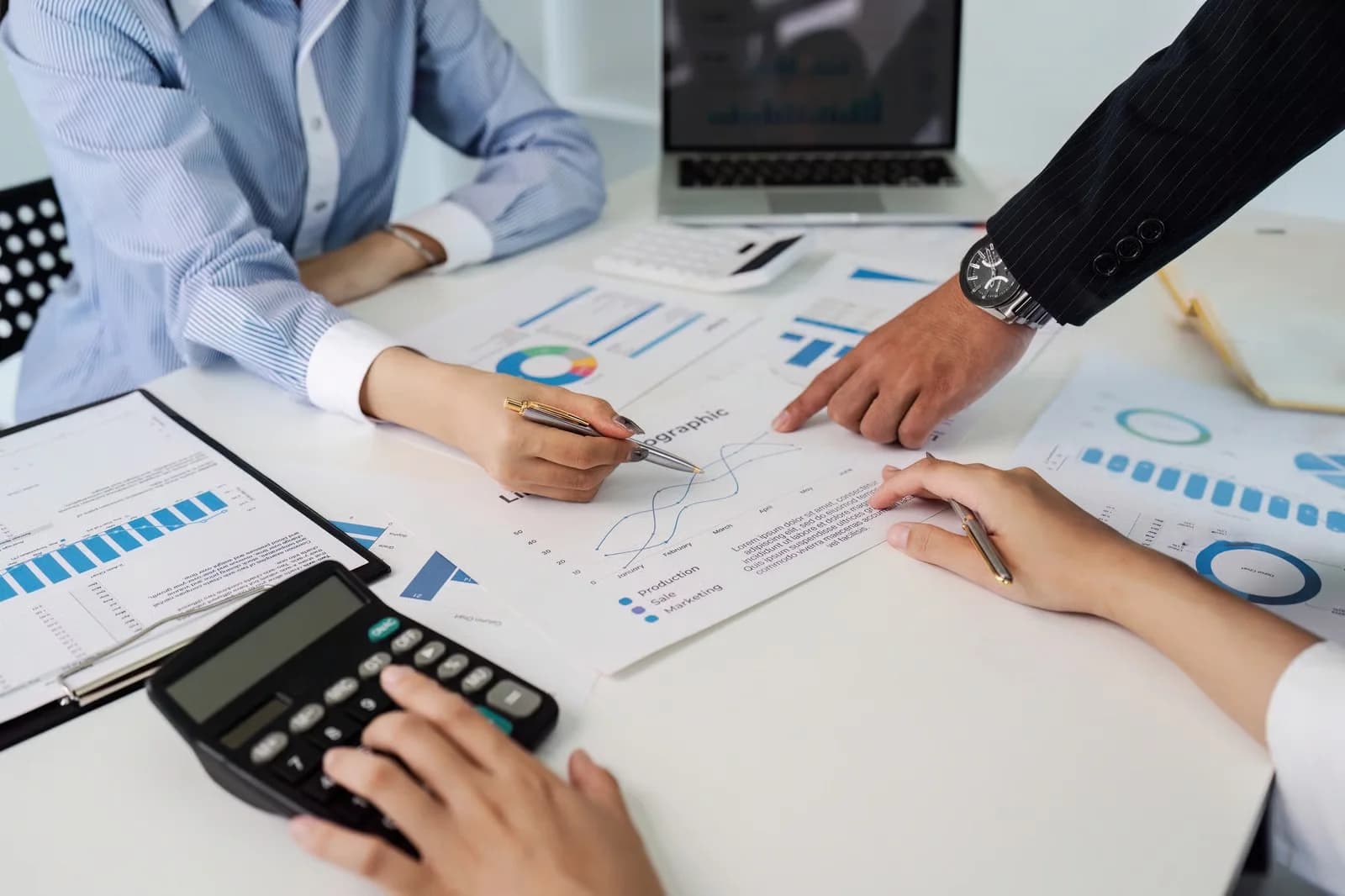 Business team reviewing payroll reports and financial calculations